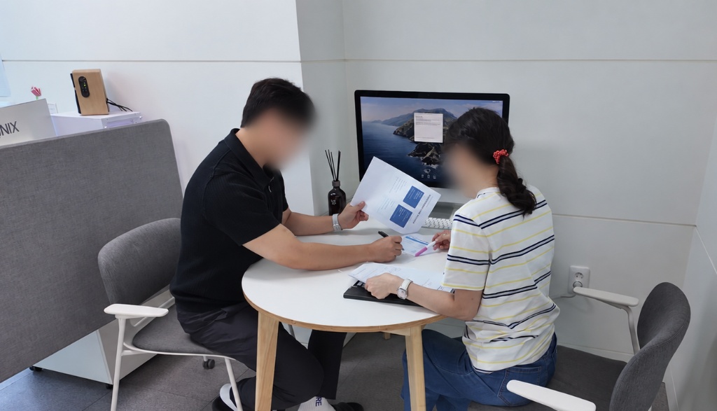 고객과 마주 앉아 서류를 보며 상담하는 모습