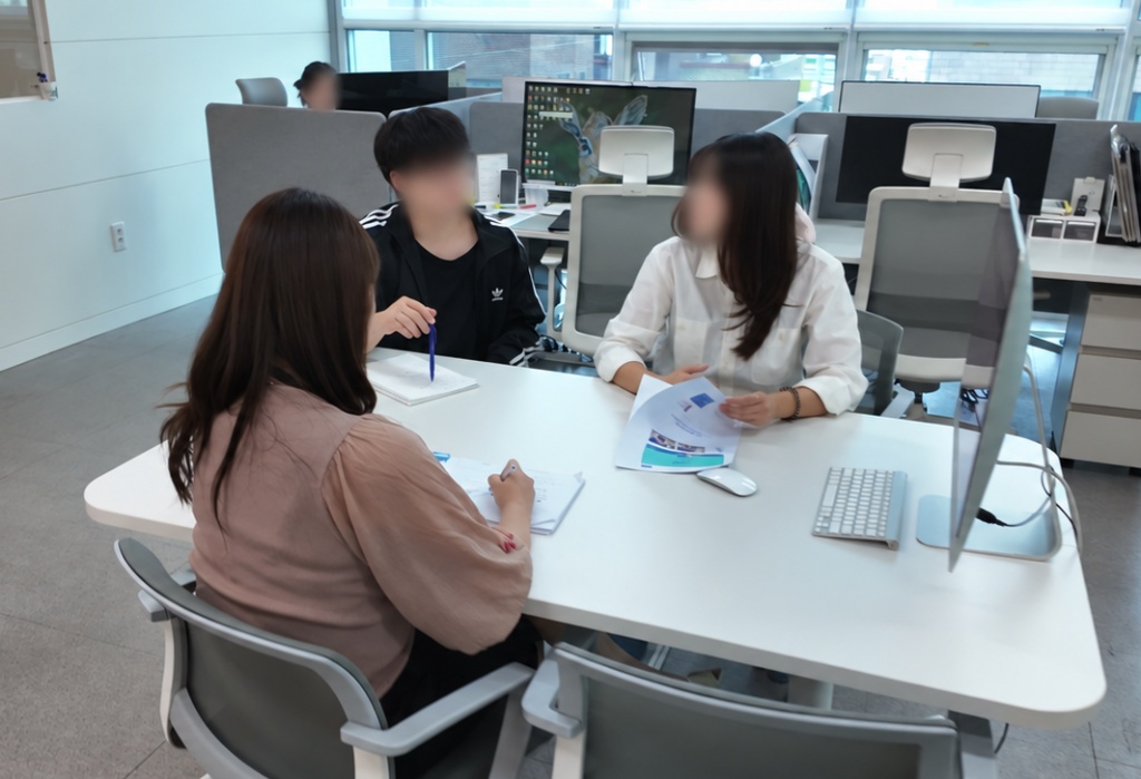 파트너사와 함께 회의 테이블에서 논의하는 커넥트온 팀원들