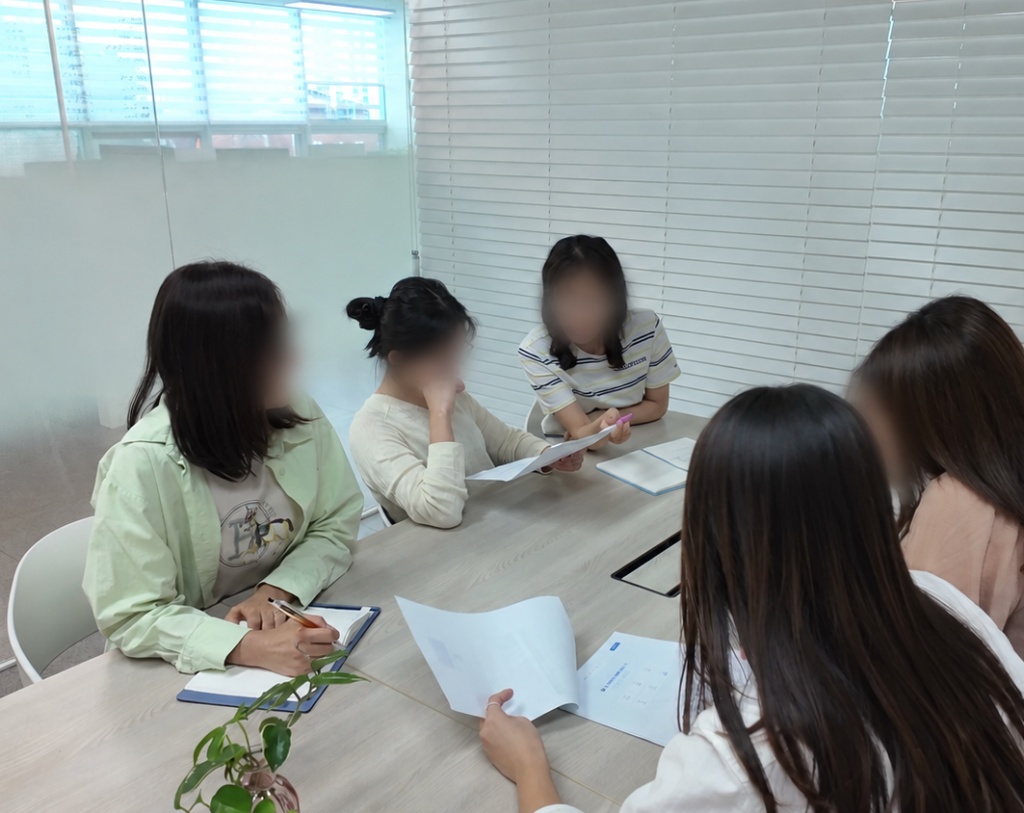 회의실에서 여러 팀원이 함께 서류를 검토하는 모습